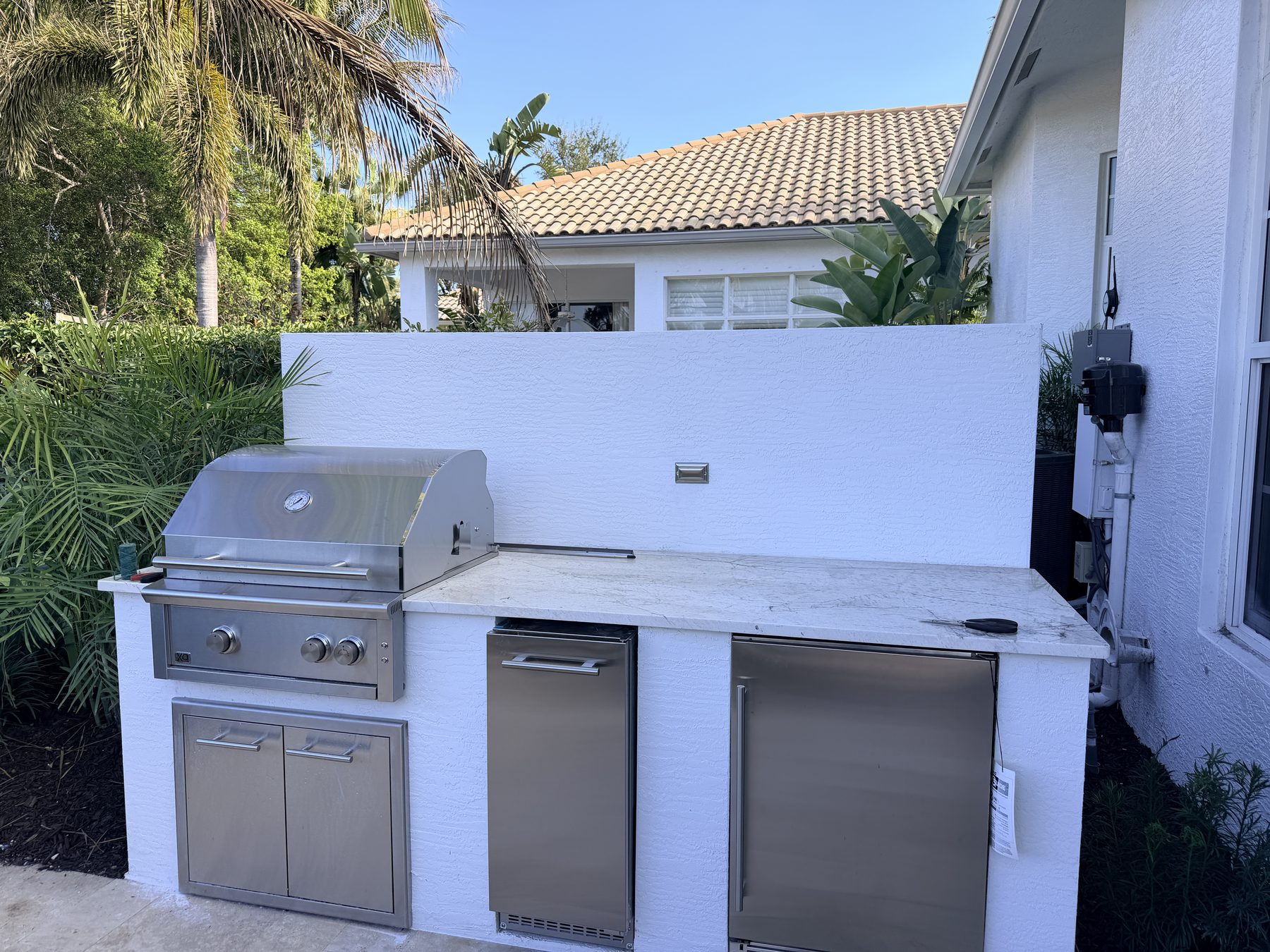 Players Court outdoor kitchen with grill and under-counter fridge